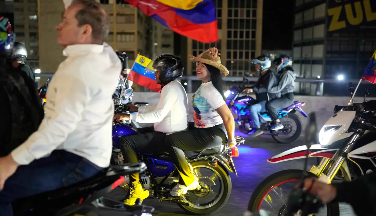 Pembebasan ini merupakan bagian dari percepatan kebijakan yang diumumkan pemerintah, menyusul perubahan besar dalam dinamika politik Venezuela. Tampak dalam foto, pemimpin oposisi María Oropeza dan Juan Pablo Guanipa mengendarai sepeda motor melalui Caracas, Venezuela, setelah dibebaskan dari tahanan, Minggu 8 Februari 2026. (AP Photo/Ariana Cubillos)