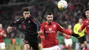 Bek Bayern Muenchen, Joao Cancelo berebut bola dengan bek Mainz 05, Aaron Martin selama pertandingan babak 16 besar Piala Jerman (DFB Pokal) di Mewa Arena, Mainz, Jerman (1/2/2023). Bermain sebagai starter, Cancelo mencetak satu assist dalam laga debutnya bersama Bayern. (AFP/Thomas Kienzle)