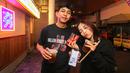 Sepasang pengunjung berpose setelah melakukan regristrasi saat Roaring Night Liga Inggris antara West Ham melawan Arsenal yang berlangsung di Triboon, Cilandak, Jakarta Selatan, Minggu (11/02/2024) malam WIB. (Bola.com/Bagaskara Lazuardi)
