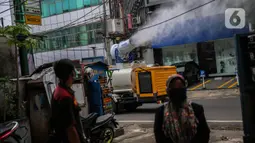 Petugas PMI dengan mobil gunners spraying menyemprotkan cairan disinfektan di kawasan Jalan Blok A, Jakarta, Kamis (30/4/2020). Untuk mencegah penyebaran COVID-19, PMI melakukan penyemprotan disinfektan berskala besar di wilayah DKI dengan memanfaatkan momen PSBB. (Liputan6.com/Faizal Fanani)