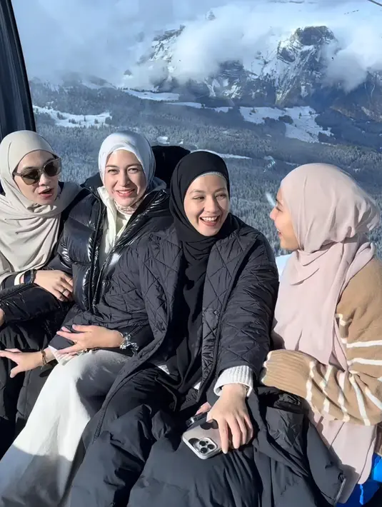 Keempatnya pun menikmati keindahan Swiss dari atas Gondola. Nina dan Natasha monokrom terlihat dari jaket dan kerudung yang dikenakan. Ratna dan Dian tampil lebih berwarna. [@albernsultan]