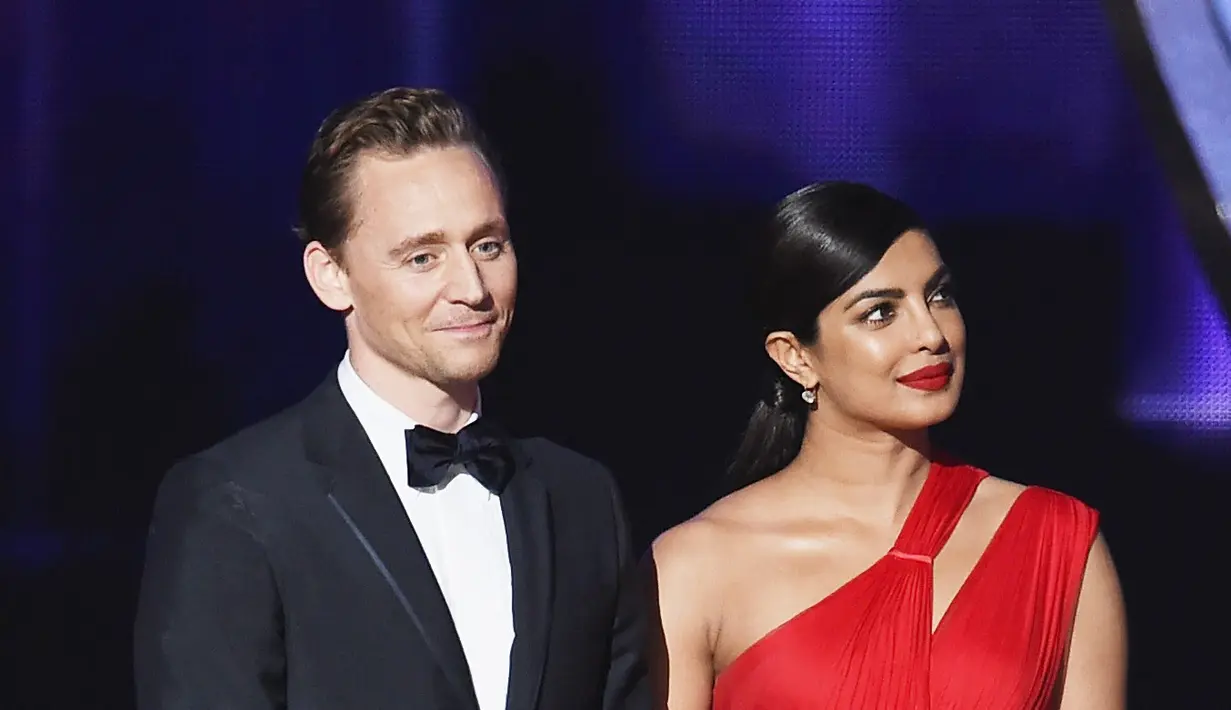 Meski baru saja putus cinta, Tom Heddleston tetap terlihat baik-baik saja saat berada di atas panggung bersama Pryanka Chopra. Beberapa kali ia terlihat melempar senyum dan terlihat romantis bersama Pryanka. (AFP/Bintang.com)