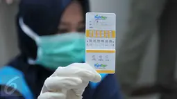 Petugas BNN menunjukkan hasil tes urine penghuni kos-kosan di Jalan Taman Sari Raya No 60-62, Jakarta (1/10). Dari razia ini, delapan orang terdiri dari tujuh wanita dan satu pria diamankan karena positif mengonsumsi narkoba. (Liputan6.com/Gempur M Surya)