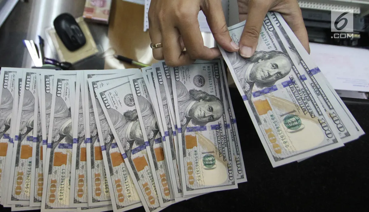 Teller tengah menghitung mata uang dolar di penukaran uang di Jakarta, Junat (23/11). Nilai tukar dolar AS terpantau terus melemah terhadap rupiah hingga ke level Rp 14.504. (Liputan6.com/Angga Yuniar)