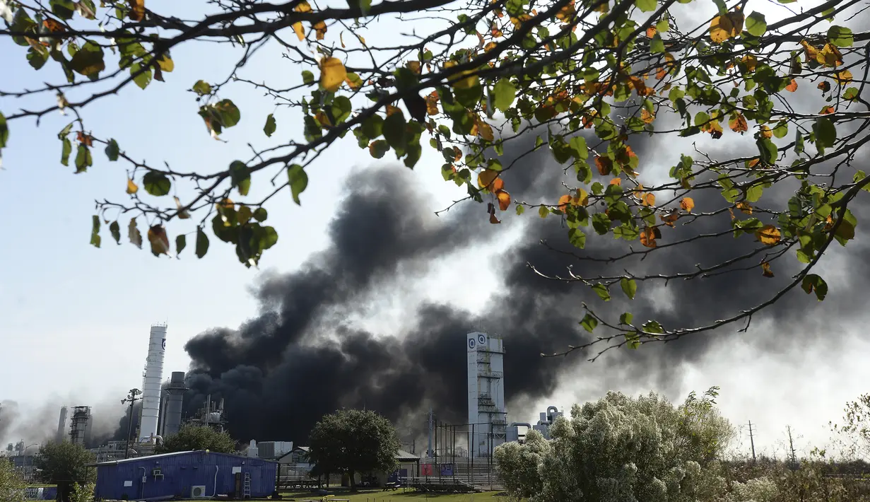 Asap tebal memenuhi langit di atas pabrik TPC saat api terus menyala setelah ledakan  Port Neches, Texas (27/11/2019). Saksi mata mengatakan ledakan yang terjadi pabrik kimia tersebut seperti sebuah bom. (Kim Brent/The Beaumont Enterprise via AP)