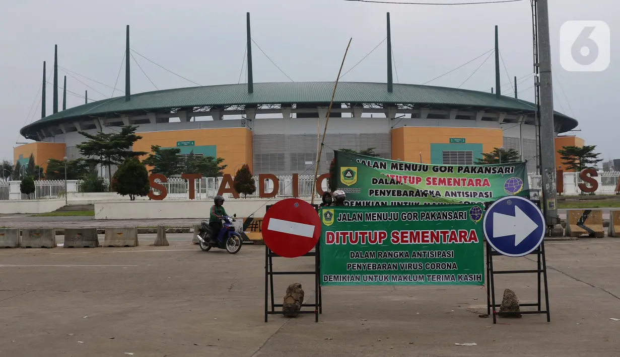 Pengendara motor melintasi jalan depan Stadion Pakansari, Kab Bogor, Jawa Barat, Senin (13/4/2020). Bupati Bogor Ade Yasin menyatakan Pembatasan Sosial Berskala Besar pencegahan penularan virus COVID-19 akan fokus di 11 kecamatan yang masuk kategori zona merah. (Liputan6.com/Helmi Fithriansyah)