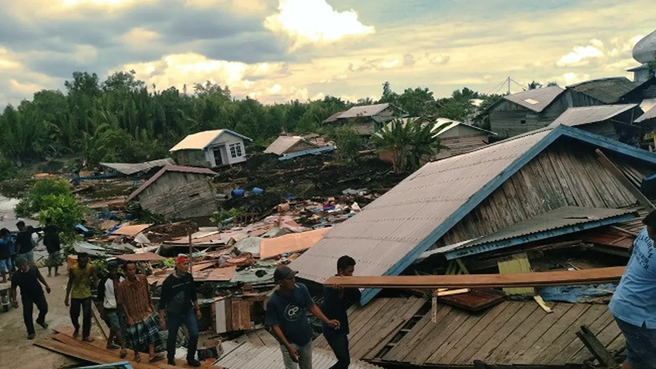 Warga korban longsor di Indragiri Hilir meninggalkan rumah yang sudah ambruk.