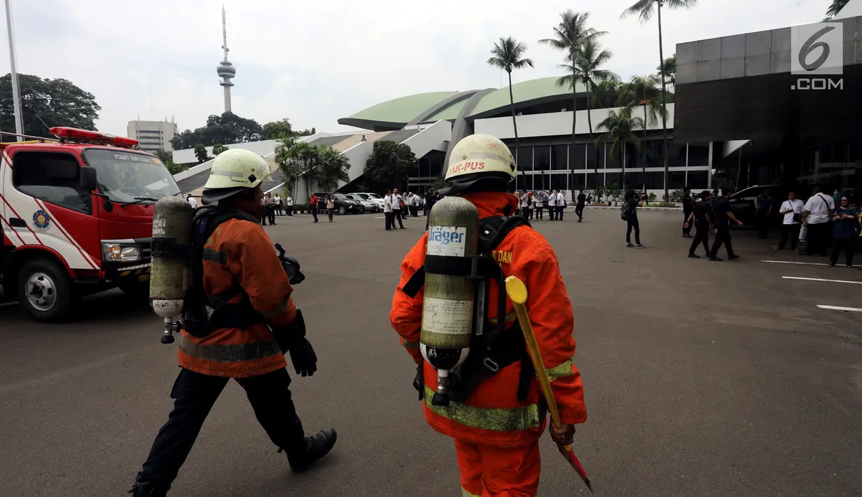 Petugas pemadam kebakaran bersiap memadamkan api di ruangan kelompok kerja (Pokja) Sipil lantai dua Gedung Nusantara III DPR, Kompleks Parlemen, Jakarta, Selasa (14/11). Diduga munculnya api akibat adanya korsleting listrik. (Liputan6.com/Johan Tallo)