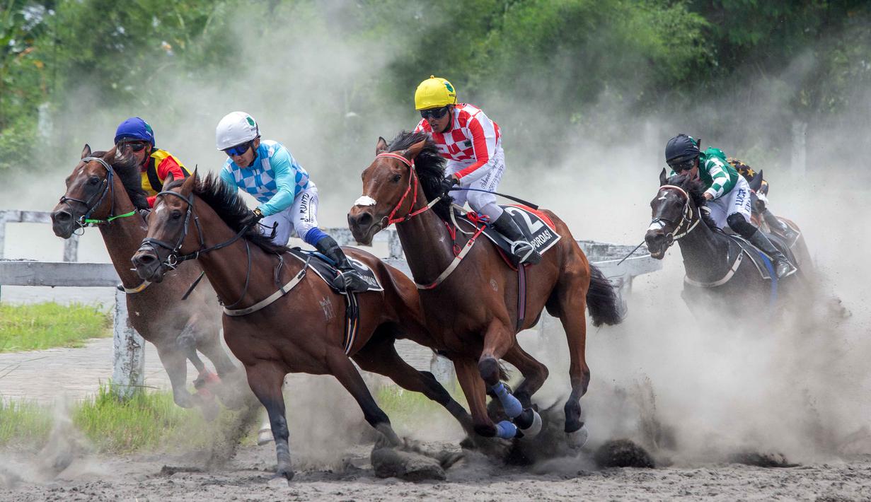 Kejuaraan ini merupakan salah satu agenda balap kuda tahunan yang menggabungkan tradisi historis keraton dengan aspek olahraga serta hiburan modern. Tampak dalam foto, joki-joki berkompetisi dalam kejuaraan balap kuda nasional tahunan yang memperebutkan trofi Sultan Hamengku Buwono X, di lintasan Sultan Agung, Bantul, Yogyakarta, pada Minggu 9 November 2025. (DEVI RAHMAN/AFP)