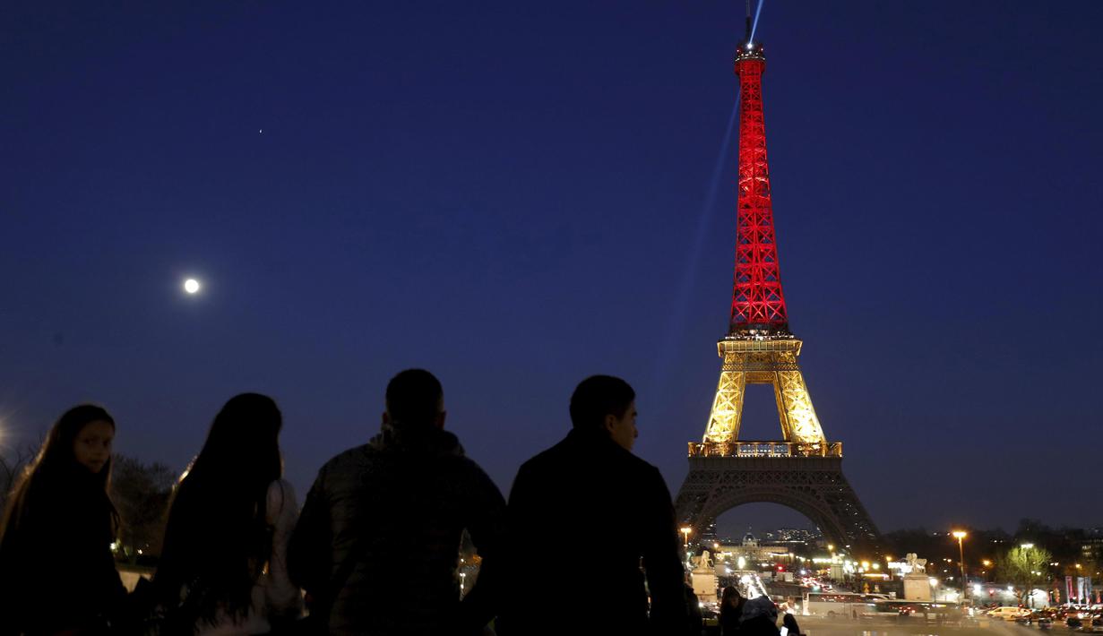 Menara Eiffel di Paris, Prancis, disinari dengan warna bendera Belgia (hitam, kuning, dan merah), Selasa (22/3). Hal itu sebagai bentuk penghormatan terhadap korban serangan bom Brussels. (REUTERS/Philippe Wojazer)