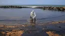 Penjaga pantai Sri Lanka bahu membahu membersihkan tumpahan minyak di sebuah pantai di Uswetakeiyawa, Kolombo, Senin (10/9). Sekitar 300 personel angkatan laut dan penjaga pantai dikerahkan untuk membersihkan daerah itu. (AP Photo/Eranga Jayawardena)