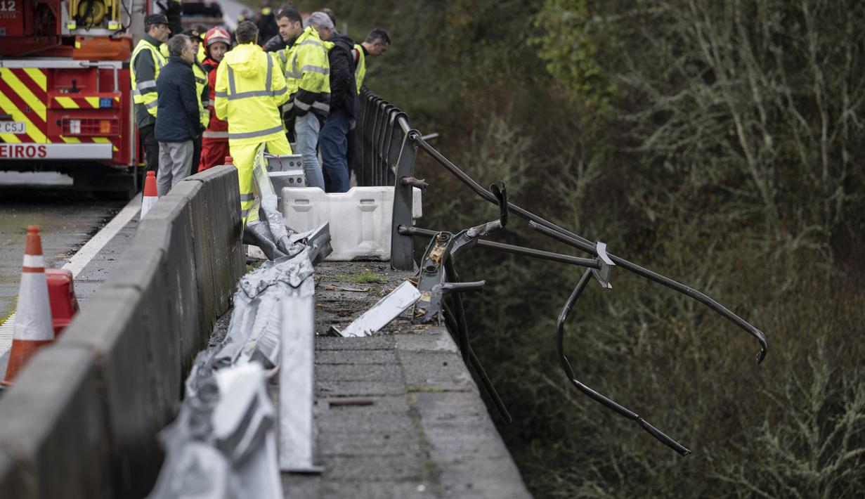 Anggota layanan darurat berdiri di jembatan setelah sebuah bus jatuh di sungai Lerez saat menyeberang, menewaskan empat orang, di Cerdedo-Cotobade, Spanyol (25/12/2022). Surat kabar regional La Voz de Galicia mengatakan bus itu membawa orang yang mengunjungi orang yang mereka cintai dipenjara di Monterroso di pusat Galicia Operasi penyelamatan harus ditangguhkan semalam karena cuaca buruk tetapi dilanjutkan di pagi hari. (AFP/Brais Lorenzo)