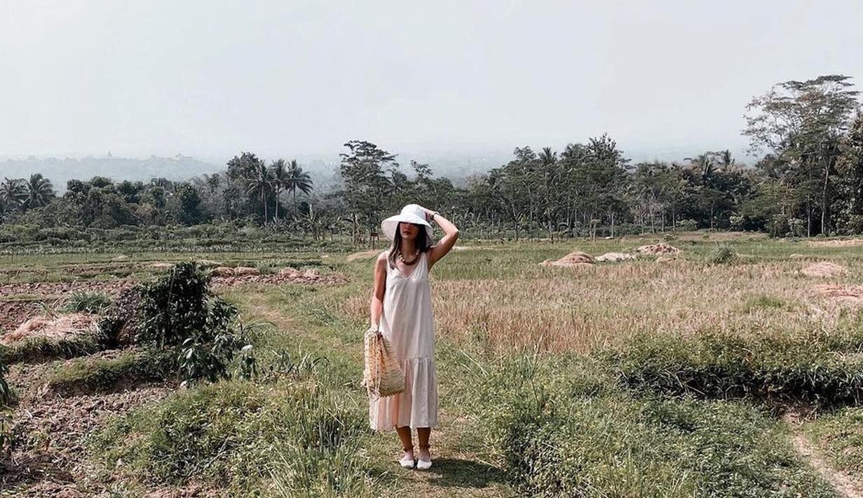 <p>Nia Ramadhani benar-benar mengeksplor seluruh tempat di Borobudur. Memakai dress polos tanpa lengan dan topi, Nia mampir ke sawah, Gaya simpel Nia yang berdiri di tengah sawah membuatnya tampak melokal. Tapi tetap dong pesona cantiknya tidak berkurang. (Instagram/ramadhaniabakrie)</p>