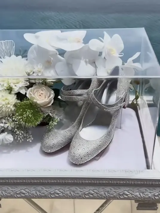 Sepasang sepatu heels silver bertabur kristal yang berkilauan. Sepatu berjenis pumps ini diketahui dari brand Prancis Christian Louboutin. Sepatu Miss Jane Crystal Red Sole Double-Buckle Pumps ini dibanderol harga Rp50 juta melihat situs Neiman Marcus [@iniseserahan]