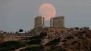 Bulan purnama hampir penuh yang menampakkan diri di langit Kuil Poseidon kuno di Cape Sounion, sekitar 70 kilometer sebelah tenggara Athena, Yunani (2/8/2020). (Xinhua/Marios Lolos)