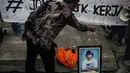 Seorang warga menabur bunga pada foto korban Tragedi Semanggi I, Bernardus Realino Norma Irmawan, di depan Kampus Unika Atma Jaya, Jakarta, Kamis (13/11/2014). (Liputan6.com/Faizal Fanani)