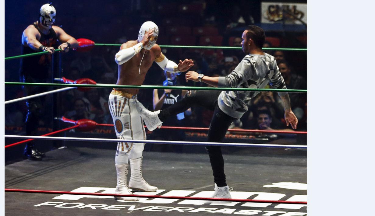 Lewis Hamilton berusaha menendang pegulat yang bintang WWE di Coliseo Arena, Mexico City, (28/10/2015). (Reuters/Henry Romero)