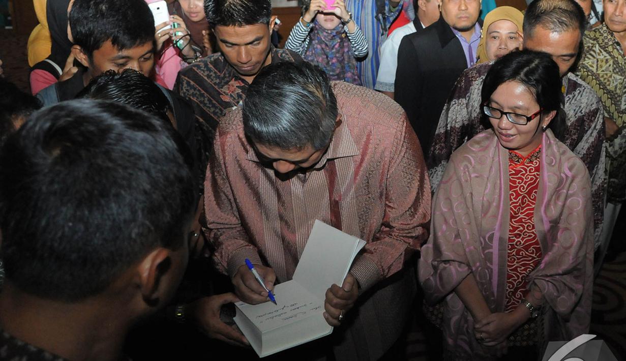 SBY membubuhkan tanda tangannya pada sebuah buku seorang mahasiswa yang ikut kuliah umum, Tangsel, Rabu (10/12/2014). (Liputan.com/Herman Zakharia)
