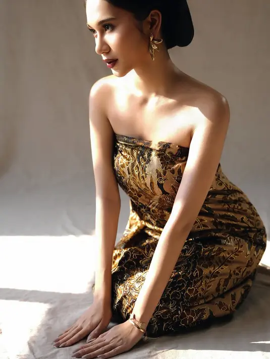 Potret berikutnya, Azizah tampil mengenakan kain batik yang di styling menjadi dress strapless memerlihatkan pundaknya. Ia pun masih mengenakan anting-anting emas kuningan besar.[@azizahsalsha_]
