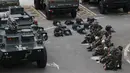 Polisi paramiliter China duduk di dekat kendaraan lapis baja di stadiun olahraga di Shenzhen, kota di dekat perbatasan dengan Hong Kong, China (30/10/2019). Ratusan polisi militer China ini dikhawatirkan Amerika Serikat akan dikirim ke Hong Kong untuk membubarkan pengunjuk rasa. (AP Photo/Andy Wong)