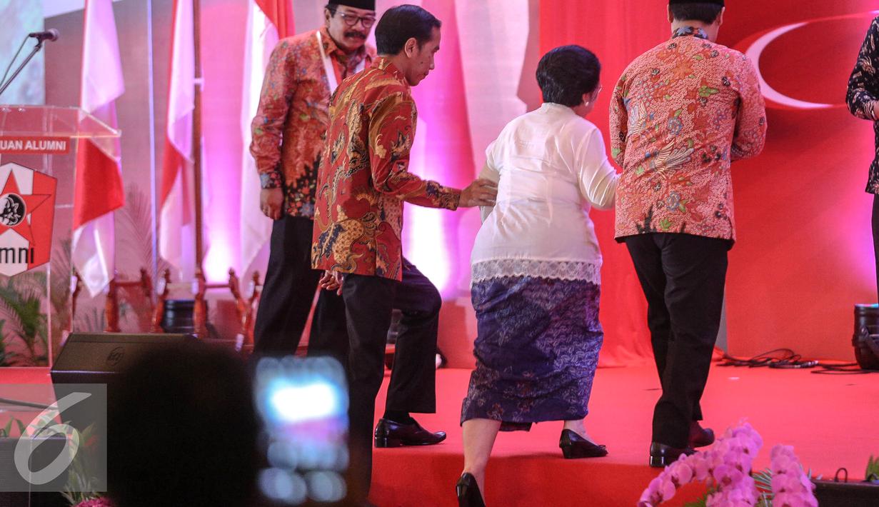 Presiden Jokowi membantu Megawati menaiki tangga pada pembukaan Kongres III Persatuan Alumni GMNI, Jakarta, Jumat (8/7/2015). Kongres bertajuk Jalan Trisakti Menuju Tatanan Masyarakat Pancasila dihadiri sekitar 1.000 peserta. (Liputan6.com/Faizal Fanani)