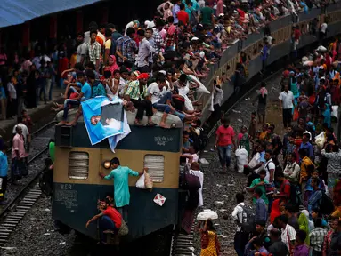 Ribuan orang tampak berdesakan menaiki atap kereta di sebuah stasiun, Dhaka, Bangladesh, Selasa (5/7). Mereka rela bersesakan untuk menuju kampung halaman pada Hari Raya Idul Fitri kali ini. (REUTERS / Adnan Abidi)