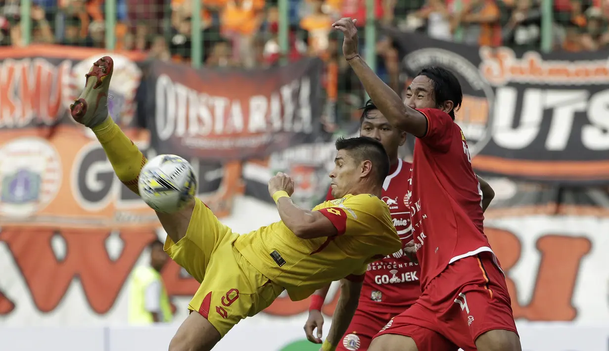 Striker Bhayangkara FC, Romiro Fergonzi, berebut bola dengan bek Persija Jakarta, Ryuji Utomo, pada laga Shopee Liga 1 di Stadion Patriot Chandrabhaga, Bekasi, Sabtu (10/8). Persija bermain imbang 1-1 atas Bhayangkara. (Bola.com/Yoppy Renato)