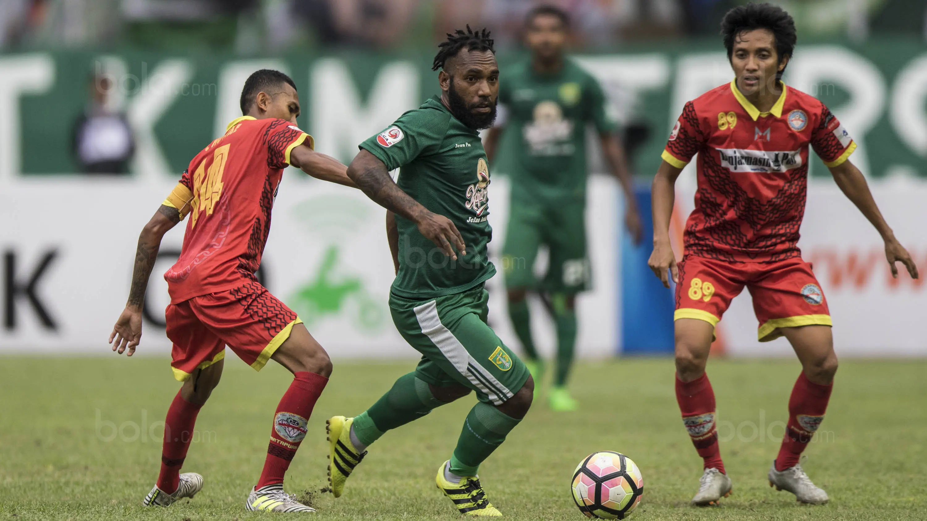 Gelandang Persebaya, Nerius Alom, berusaha melewati kepungan pemain Martapura FC pada laga semifinal Liga 2 2017 di Stadion GBLA, Bandung, Sabtu (25/11/2017). Persebaya menang 3-1 atas Martapura FC. (Bola.com/Vitalis Yogi Trisna)