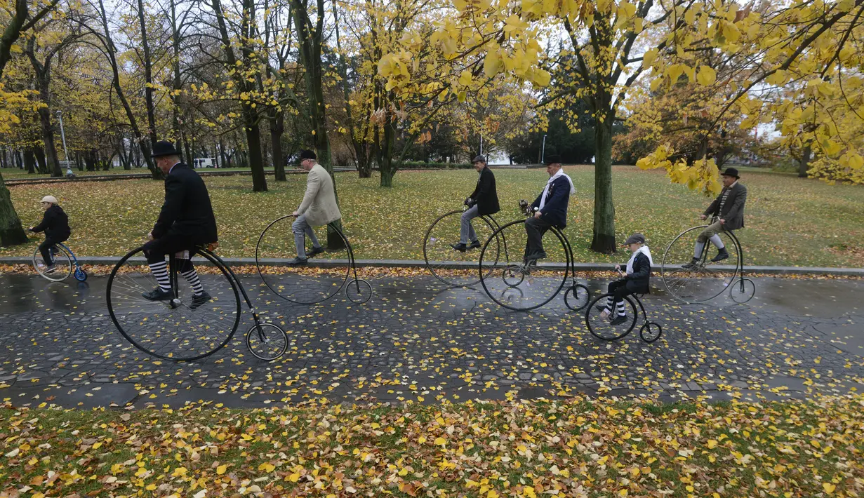 Para penggemar sepeda mengenakan kostum sejarah sambil mengendarai Penny Farthing atau dikenal sebagai sepeda roda tinggi selama kompetisi tradisonal 'One Mile Race' di Praha, Republik Ceko pada 3 November 2018. (Photo by Michal CIZEK / AFP)