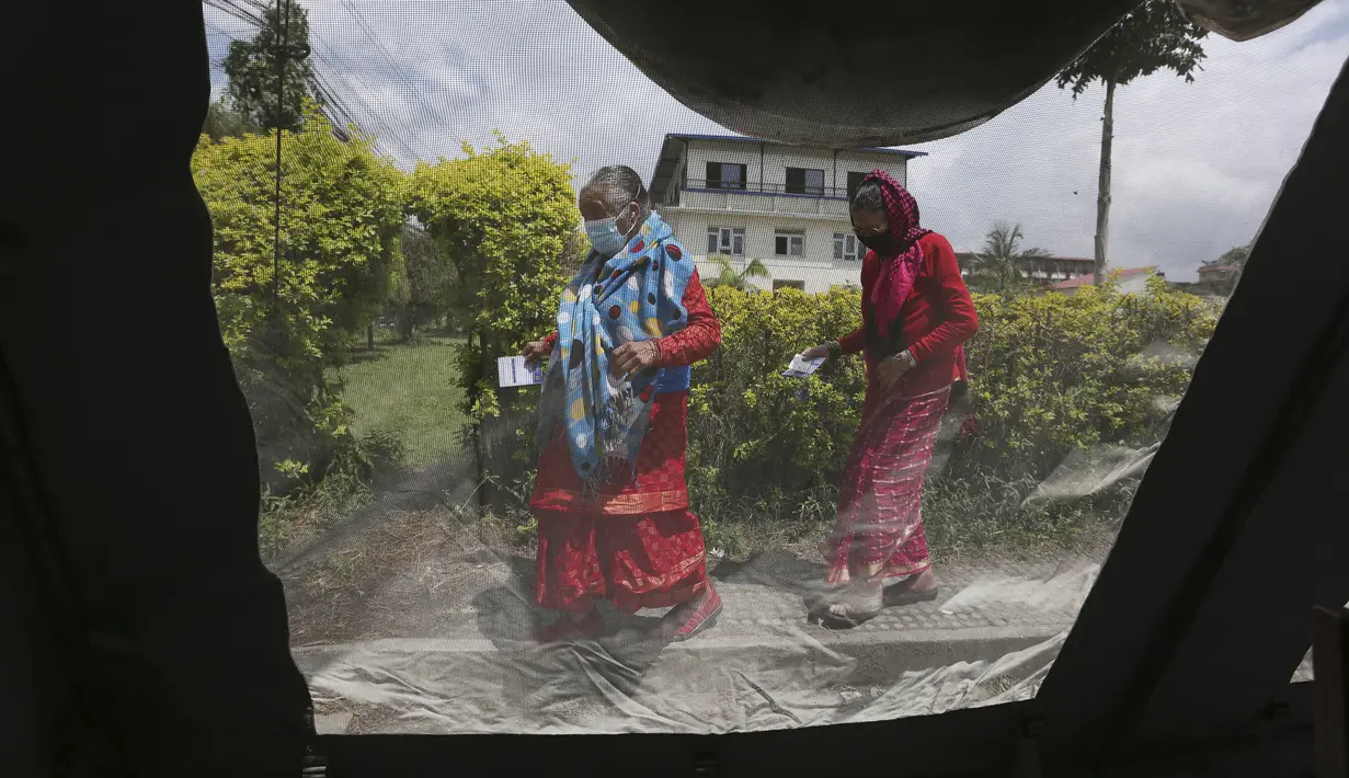 Lansia tiba untuk menerima vaksin virus corona COVID-19 AstraZeneca terlihat dari dalam tenda vaksinasi di Kathmandu, Nepal, Senin (9/8/2021). Hingga 8 Agustus 2021, kasus virus corona COVID-19 Nepal mencapai 717.486. (AP Photo/Niranjan Shrestha)