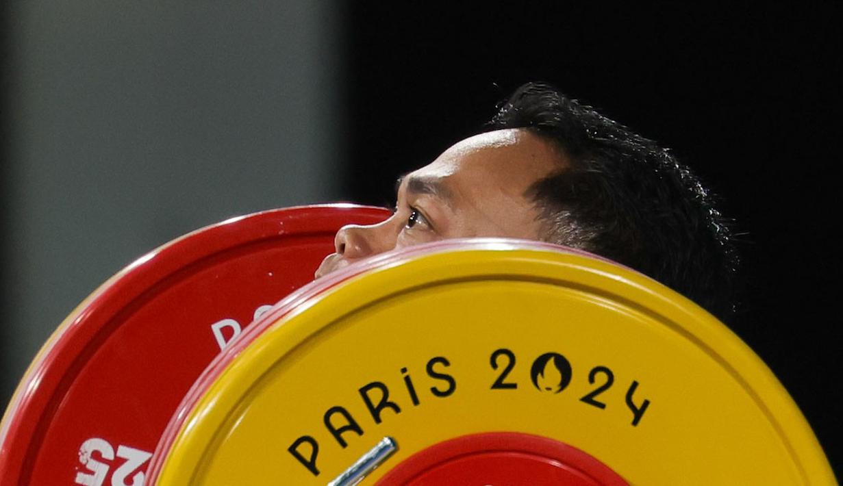 Lifter Indonesia, Eko Yuli Irawan melakukan angkatan clean and jerk pada cabang olahraga angkat besi 61 kg putra Olimpiade 2024 di South Paris Arena, Paris, Prancis, Rabu (07/08/2024). (Dok. NOC Indonesia/Naif Muhammad Al'as)