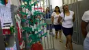 Narapidana perempuan meninggalkan sel untuk menghadiri acara tahunan menjelang  natal di Penjara Nelson Hungria, Rio de Janeiro, Kamis (13/12). Para tahanan juga menyanyikan lagu religi dan memainkan drama perjalanan hidup Yesus. (AP/Silvia Izquierdo)