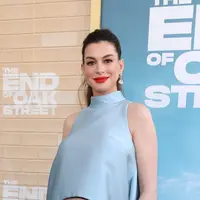 Anne Hathaway tunjukkan pesona bumil edgy dengan atasan asimetris dan jeans (Photo by VALERIE MACON / AFP)