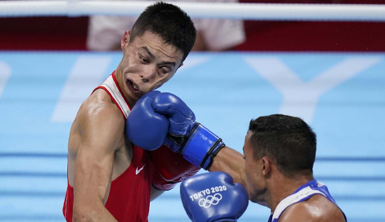 Hook dari petinju asal Puerto Rico, Yankiel Rivera Figueroa mengenai muka dari Saken Bibossinov asal Kazakhstan, dalam pertandingan tinju kelas terbang 52 kg putra Olimpiade Tokyo 2020, Senin (26/7/2021). (Foto: AP/Frank Franklin II)