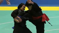 Aksi pesilat Laos, Olahthai Sounthavong beursaha membanting Octaviani Nirmalasari (kanan) pada semifinal Test Event Pencak Silat 2018 di Padepokan Silat TMII, Jakarta, (12/2/2018). Oktaviani menang 5-0. (Bola.com/Nick Hanoatubun)