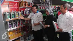 Direktur Sales & Marketing PT Pertamina Lubricants Andria Nusa (kanan) menjelaskan outlet Bright Olimart di SPBU Cakung, Jakarta, Senin (26/10). Outlet ini merupakan pelayanan servis pengendara bermotor. (Liputan6.com/Angga Yuniar)