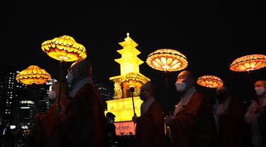 Biksu Buddha Korea Selatan mengenakan masker membawa lentera teratai berwarna-warni selama upacara pencahayaan untuk merayakan ulang tahun Buddha yang akan datang pada 8 Mei, di Seoul, Korea Selatan (5/4/2022). (AP Photo/Lee Jin-man)