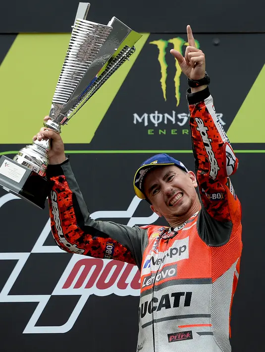 Pembalap Spanyol dari tim Ducati, Jorge Lorenzo mengangkat tropi usai memenangkan balapan MotoGP Catalunya di Sirkuit Catalunya di Montmelo, (17/6). (AFP PHOTO / Josep Lago)
