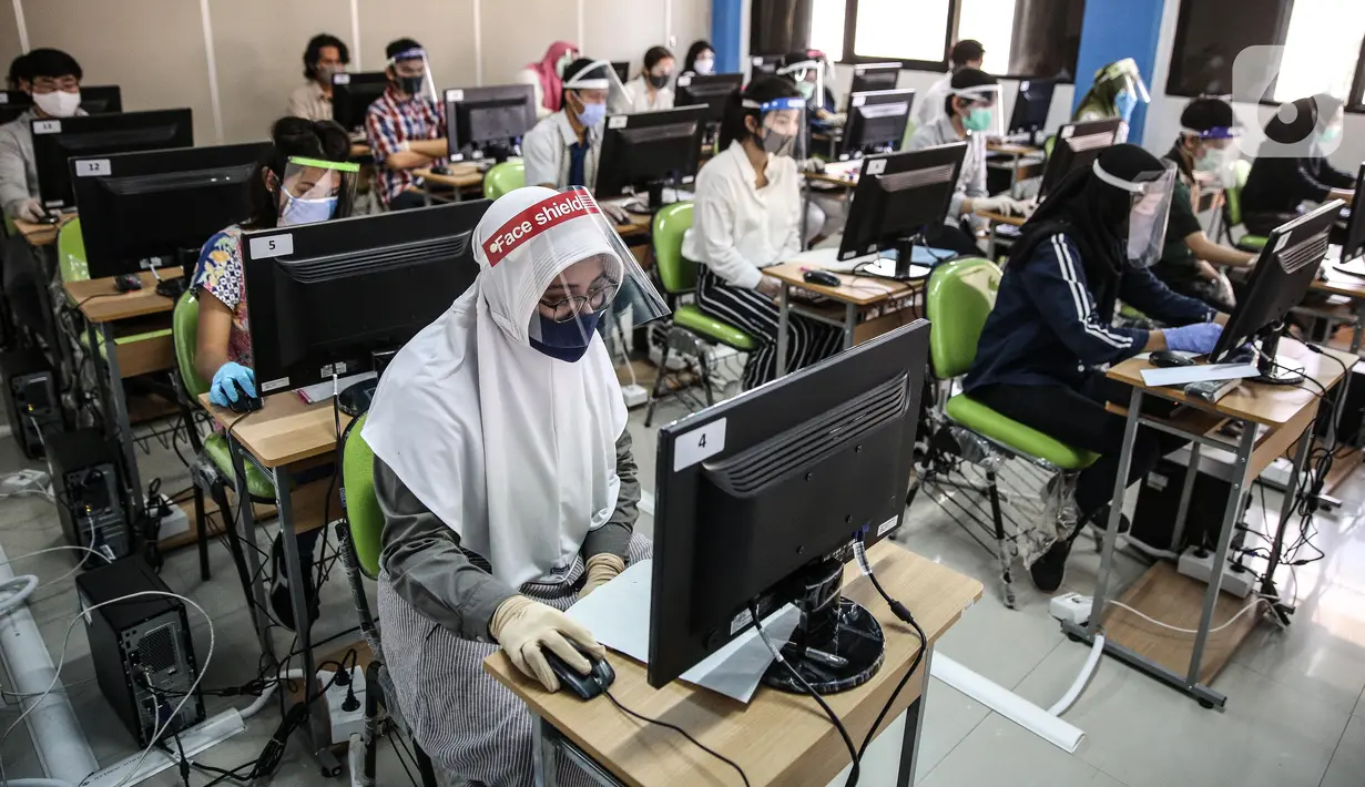 Sejumlah peserta mengenakan masker, pelindung wajah, dan sarung tangan saat mengikuti Seleksi Bersama Masuk Perguruan Tinggi Negeri (SBMPTN) di Universitan Negeri Jakarta, Minggu (5/7/2020). Sebanyak 42.463 peserta mengikuti SBMPTN dengan prosedur protokol kesehatan. (Liputan6.com/Faizal Fanani)