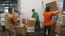 Petugas merapikan karton berisi alat kesehatan bantuan investor China di Terminal Kargo 530 Bandara Internasional Soekarno Hatta, Jumat (27/3/2020). Bantuan terdiri dari test kit COVID-19, swab kit, masker, hingga alat pelindung diri (APD). (Liputan6.com/Herman Zakharia)