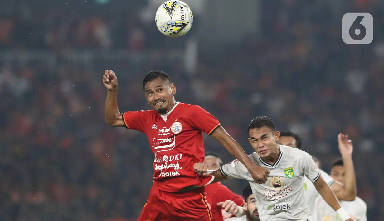 Gelandang Persija, Ramdani Lestaluhu (kiri) berebut bola dengan pemain tengah Persebaya, Abu Rizal Maulana pada lanjutan Shopee Liga 1 Indonesia di Stadion Utama Gelora Bung Karno Jakarta, Selasa (17/12/2019). Persija kalah 1-2 dari Persebaya. (Liputan6.com/Helmi Fithriansyah)