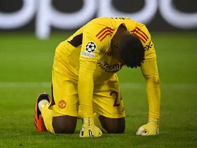 Kiper baru Manchester United, Andre Onana kembali jadi sorotan. Perannya untuk menggantikan posisi David De Gea tak berjalan mulus. Blunder demi blunder dibuatnya pada awal musim 2023/2024. Teranyar, kiper asal Kamerun tersebut harus kebobolan empat gol hingga akhirnya takluk 3-4 dari Bayern Munchen pada laga matchday pertama Grup A Liga Champions 2023/2024 di Allianz Arena, Munich, Kamis (21/9/2023) dini hari WIB. Dari empat gol yang bersarang, gol pertama yang dilesakkan Leroy Sane pada menit ke-28 mutlak menjadi blunder Onana. Bola yang mengarah tepat ke arahnya tak mampu ditangkap dengan sempurna, hingga akhirnya lepas dan masuk ke dalam gawang. (AFP/Tobias Schwarz)