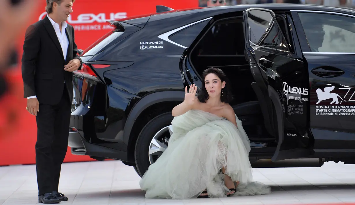 Aktris Matilda de Angelis membetulkan sepatunya saat tiba menghadiri pemutaran perdana film "Una Famiglia" dalam Festival Film Venice ke-74 di Venice Lido, Italia (4/9). (AFP Photo/Tiziana Fabi)