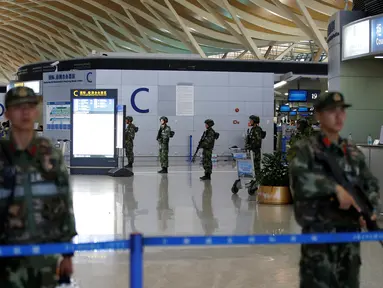 Polisi militer berjaga di dekat lokasi ledakan di Bandara Internasional Pudong, Shanghai, China, Minggu (12/6). Ledakan yang disebabkan "bahan peledak buatan" terjadi tak jauh dari lokasi penjuakan tiket di terminal dua bandara itu. (REUTERS/Aly Song)