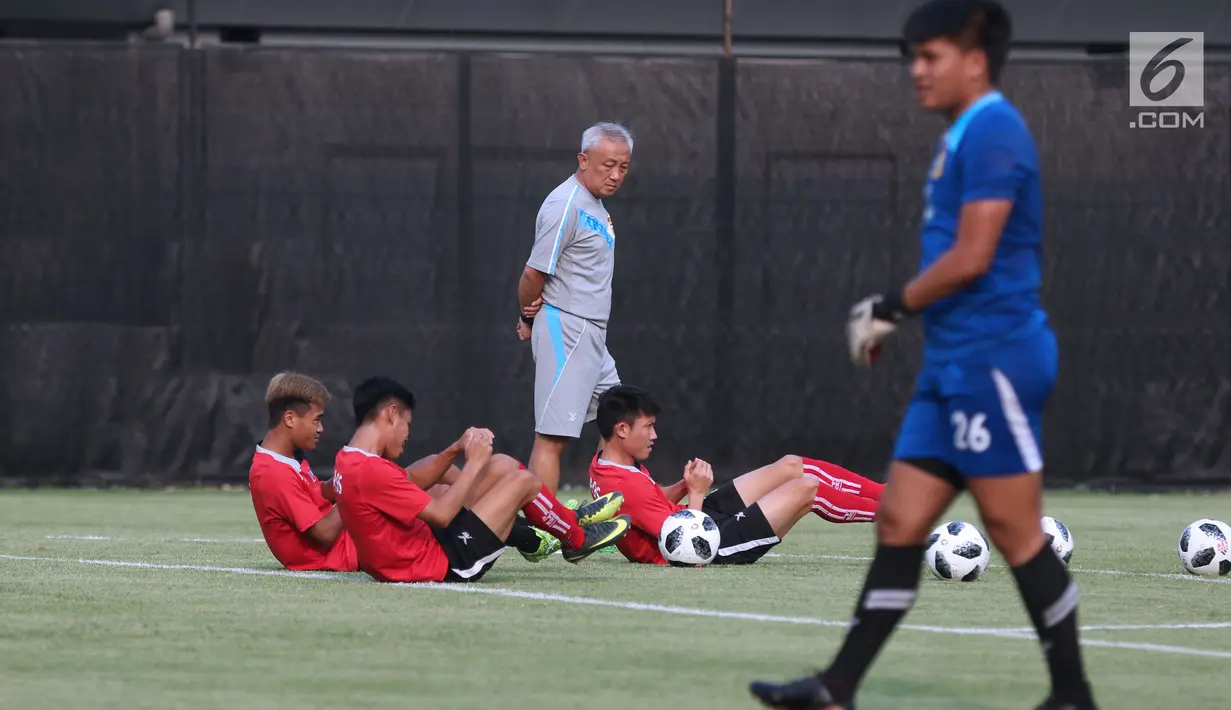 Pelatih timnas Laos, Mike Wong (tengah) mengecek kondisi pemainnya saat latihan resmi di Lapangan B, Kompleks GBK, Jakarta, Kamis (16/8). Laos menantang timnas Indonesia pada lanjutan penyisihan Grup A, Jumat (17/8). (Liputan6.com/Helmi Fithriansyah)