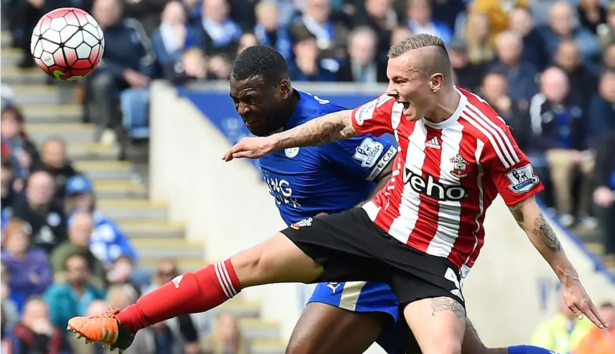 Pemain Leicester, Wes Morgan (kiri), berebut bola dengan pemain Southampton, Jordy Clasie, dalam laga Liga Inggris di Stadion King Power, Leicester, Minggu (3/4/2016). (AFP/Ben Stansall)