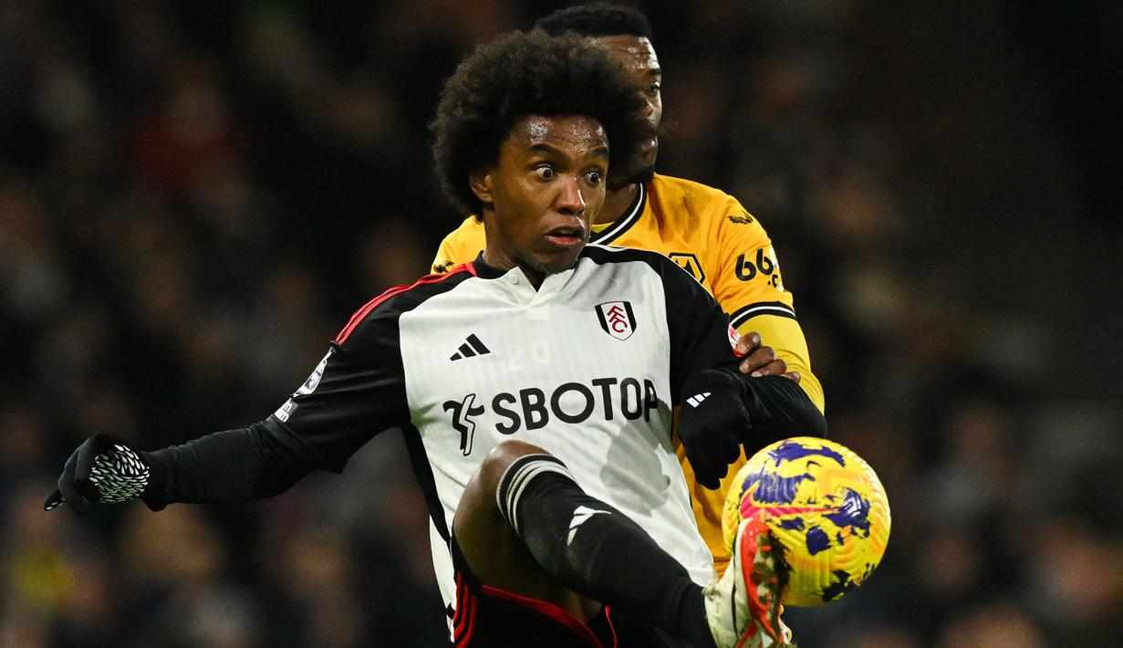 Sayap kiri asal Brasil, Willian Borges yang kini tengah menjalani musim kedua bareng Fulham baru saja masuk dalam 4 besar pesepak bola Amerika Selatan dengan penampilan terbanyak di Premier League dengan penampilan ke-300 saat Fulham menang 5-0 atas Nottingham Forest pada laga pekan ke-15 Liga Inggris musim 2023/2024. Selain Fulham ia juga pernah membela Chelsea dan Arsenal di Premier League. (AFP/Glyn Kirk)