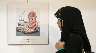 Pengunjung wanita Iran melihat kartun Presiden AS Donald J. Trump di sebuah pameran kartun Trumpisme 2017 Internasional dan kontes karikatur, di ibukota Teheran, Iran (3/7). (AFP Photo/Atta Kenare)