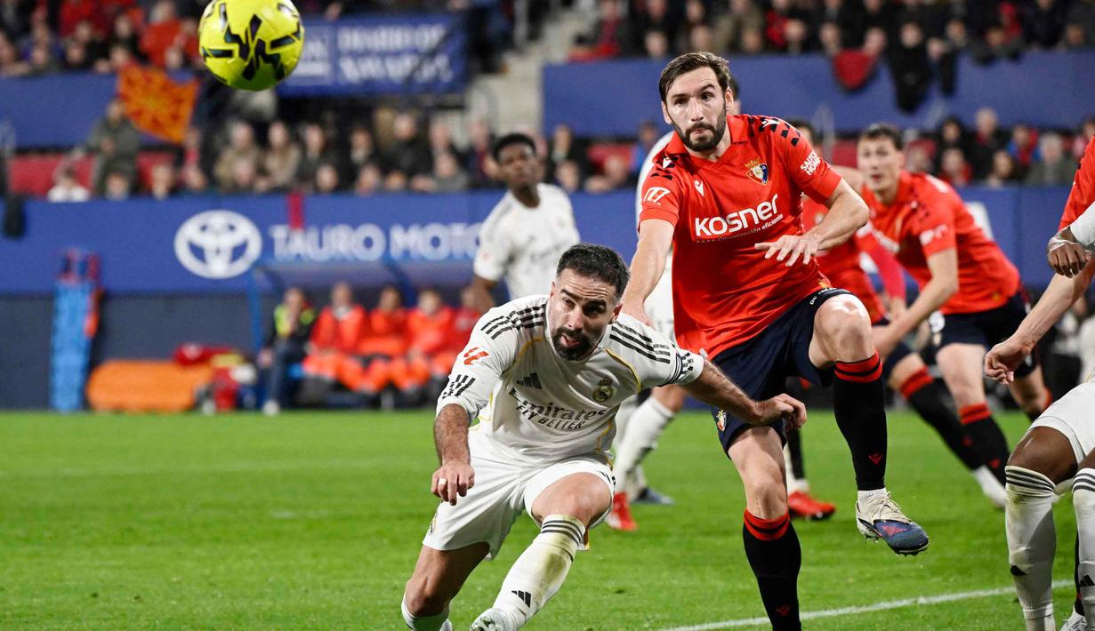 Di babak kedua, Real Madrid tampil lebih agresif dengan penguasaan bola yang lebih tinggi. Tampak dalam foto, bek Real Madrid asal Spanyol, Dani Carvajal (kiri) berebut bola dengan gelandang Osasuna asal Spanyol, Jon Moncayola, selama pertandingan pekan ke-25 La Liga 2025/2026 di Stadion El Sadar, Pamplona pada Sabtu 21 Februari 2026 waktu setempat atau Minggu (22/2/2026) dini hari WIB. (ANDER GILLENEA/AFP)