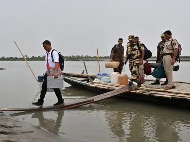 Seorang petugas pemilu membawa Mesin Pemungutan Suara Elektronik (EVM) ke sebuah tempat pemungutan suara dari sebuah kapal di Lohore Chapori di distrik Golaghat, di negara bagian Assam, India pada tanggal 18 April 2024. (Biju BORO/AFP)